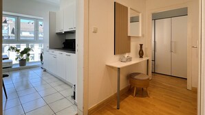 A modern kitchen with white cabinets, a black stove, and a potted plant. - Central apartment in Düsseldorf: 2 beds, elevator, WiFi – Ideal for trade fairs (Düsseldorf)