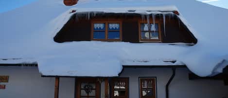 A house with a snow-covered roof and a chimney.