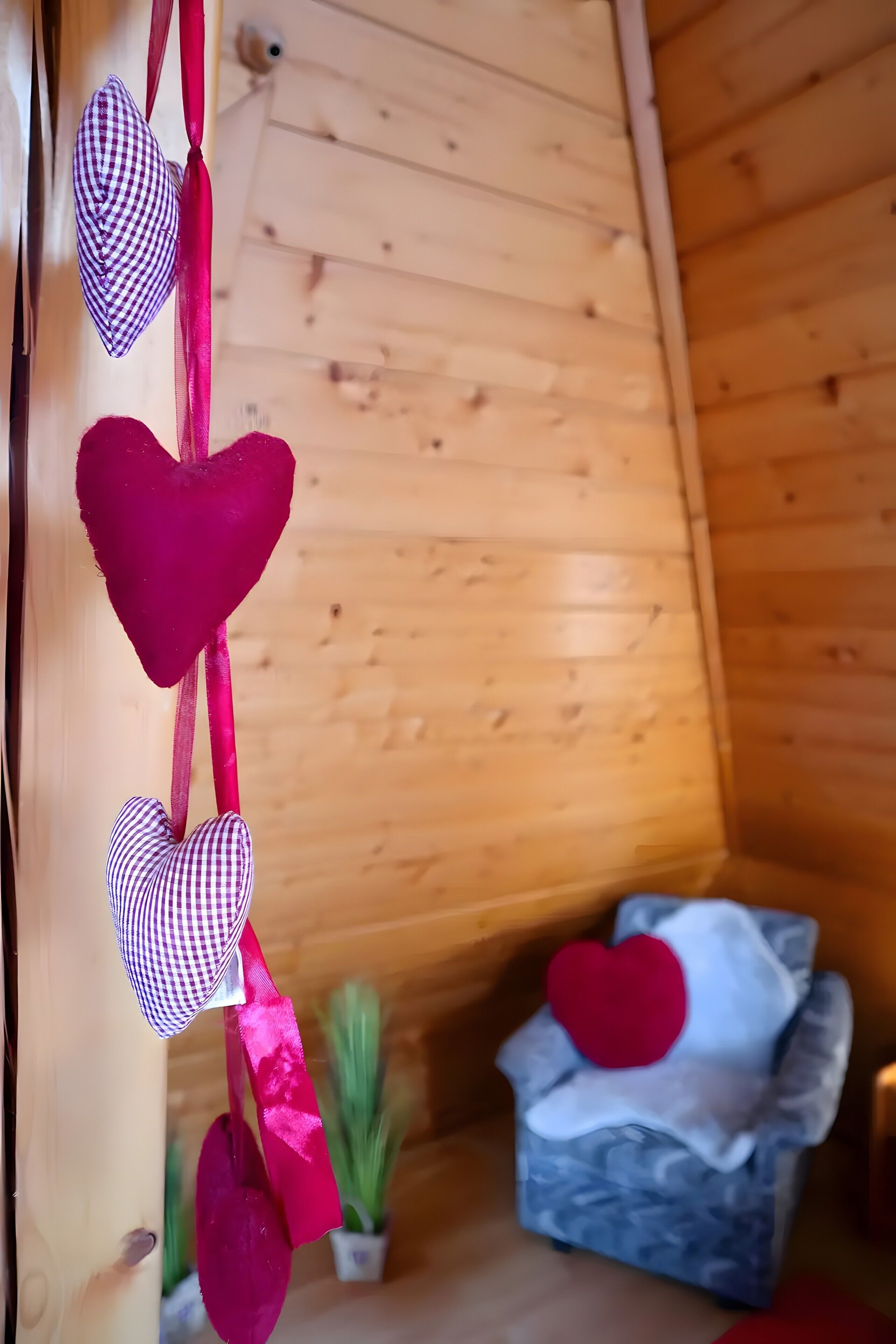 Een houten kamer met een bed en decoraties in de vorm van harten.