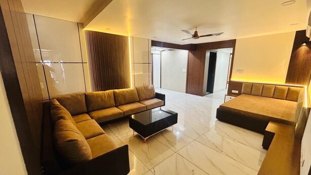 Un salon moderne avec un canapé d’angle, une table basse et un ventilateur de plafond.