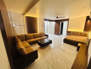 Una sala moderna con un sofá modular, una mesa de centro y un ventilador de techo.