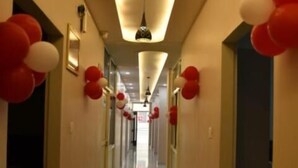A hotel hallway with a polished floor, red and white balloons, and a modern light fixture. - HOTEL SHIVANSH (Sikar)