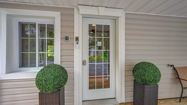 A front door with a glass panel, a keypad, and a small sign above it. - Huge home w/Game Room, Grill, Hot Tub, 3 living room, 2 bonus room, top location (Albrightsville)