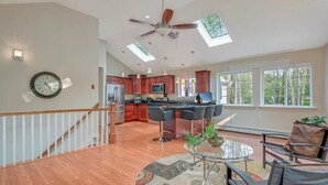 A spacious kitchen with modern appliances, a dining area with a glass table, and a staircase leading to another level. - Huge home w/Game Room, Grill, Hot Tub, 3 living room, 2 bonus room, top location (Albrightsville)