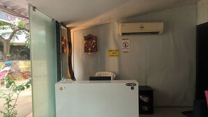 Zona de recepción con mostrador de salida, un cartel que prohíbe el alcohol y un cartel que indica que no se aceptan tarjetas de crédito.