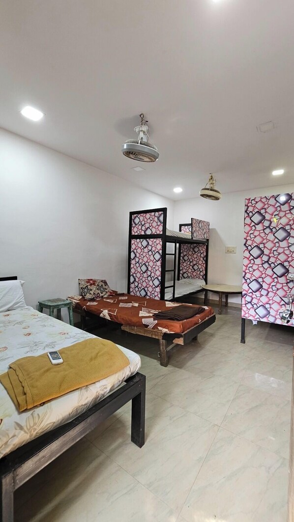 A room with two bunk beds, a small table, and a decorative partition.