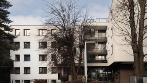 Un immeuble résidentiel à plusieurs étages, doté d’un style architectural moderne, avec des balcons et de grandes fenêtres.