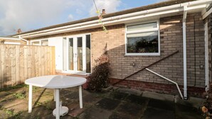 A residential house with a brick exterior, a white front door, and a window. - Megstone (Chathill)