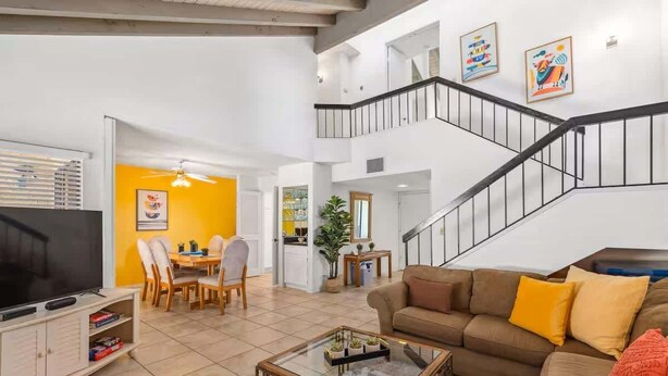 A spacious living area with a TV, sofa, coffee table, and dining area. - @ Marbella Lane - Gem w/ Outdoor Fun Pool & Trails (Palm Springs)