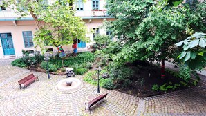 Une cour avec un motif circulaire en briques, des bancs et une fontaine.