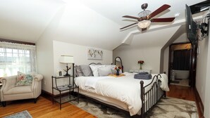 A bedroom with a bed, a chair, a desk, a ceiling fan, and a window. - Boutique Conshohocken (near Philadelphia) King & Queen Suite - Breakfast Included (Conshohocken)