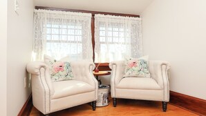 A corner room with two armchairs, a small round table, and a decorative rug. - Boutique Conshohocken (near Philadelphia) King & Queen Suite - Breakfast Included (Conshohocken)