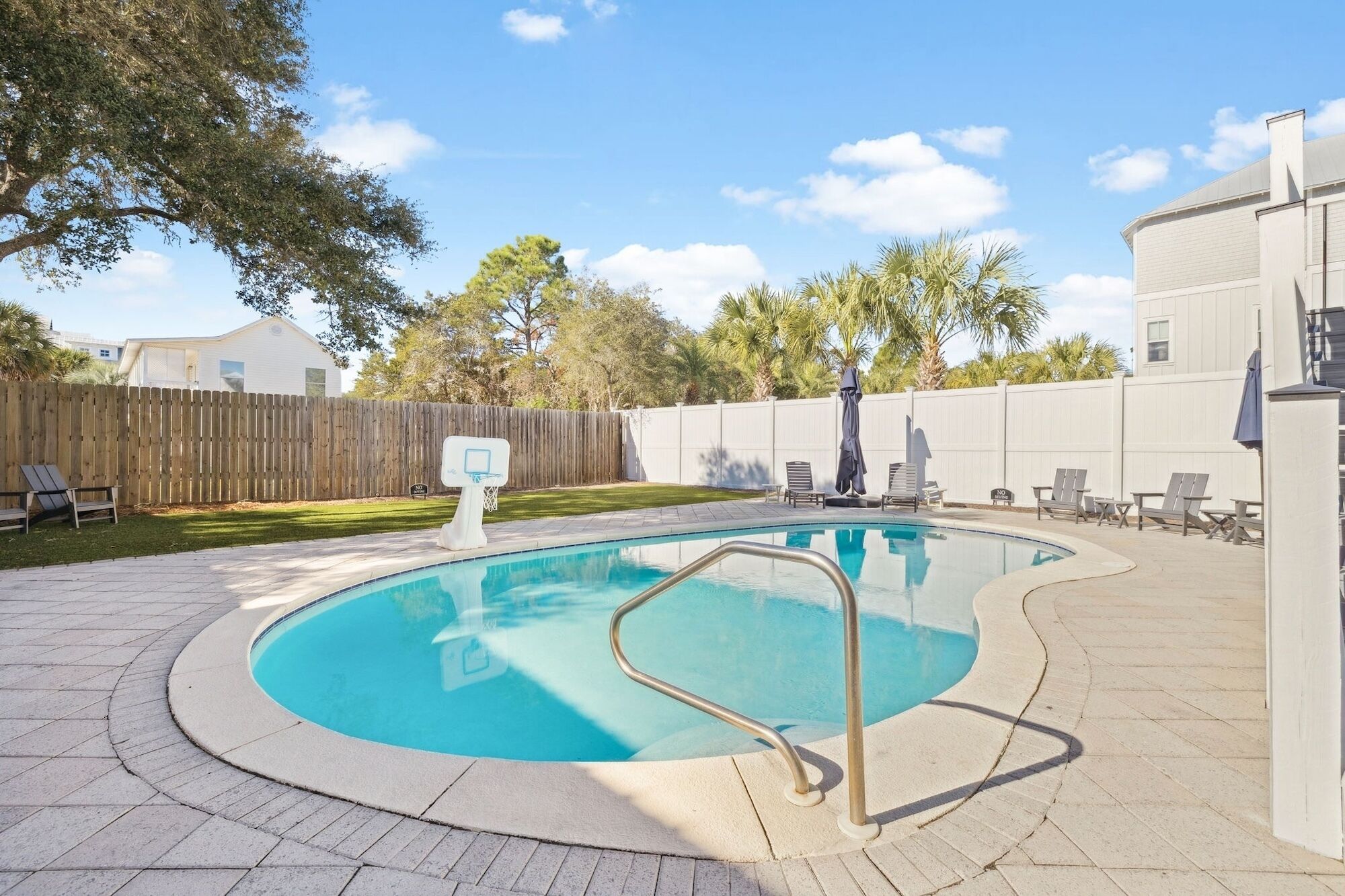 Private backyard oasis features sparkling pool surrounded by lush landscaping and comfortable lounge chairs for your perfect getaway.