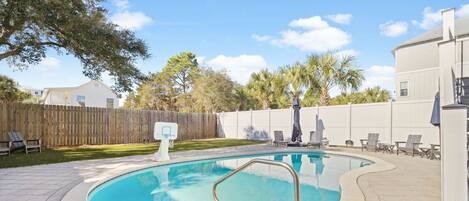 Private backyard oasis features sparkling pool surrounded by lush landscaping and comfortable lounge chairs for your perfect getaway.