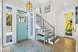 A home interior with a staircase, a blue door, and a yellow door. - Rooftop Gulf Views & Private Pool (Santa Rosa Beach)