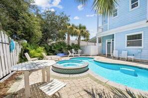 A backyard with a swimming pool, lounge chairs, and a wooden deck. - Rooftop Gulf Views & Private Pool (Santa Rosa Beach)