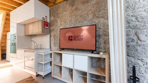 Une cuisine moderne équipée d’un four encastré, d’un évier et d’un téléviseur à écran plat affichant le message « PRÊT POUR LES INVITÉS ».