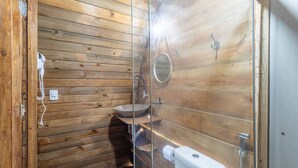 A wooden cabin bathroom with a wooden sink, a mirror, and a toilet. - Beachfront Cabins in Bahia – OTX (Porto Seguro)