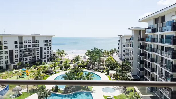 A resort with a pool, beach view, and multiple-story buildings.
