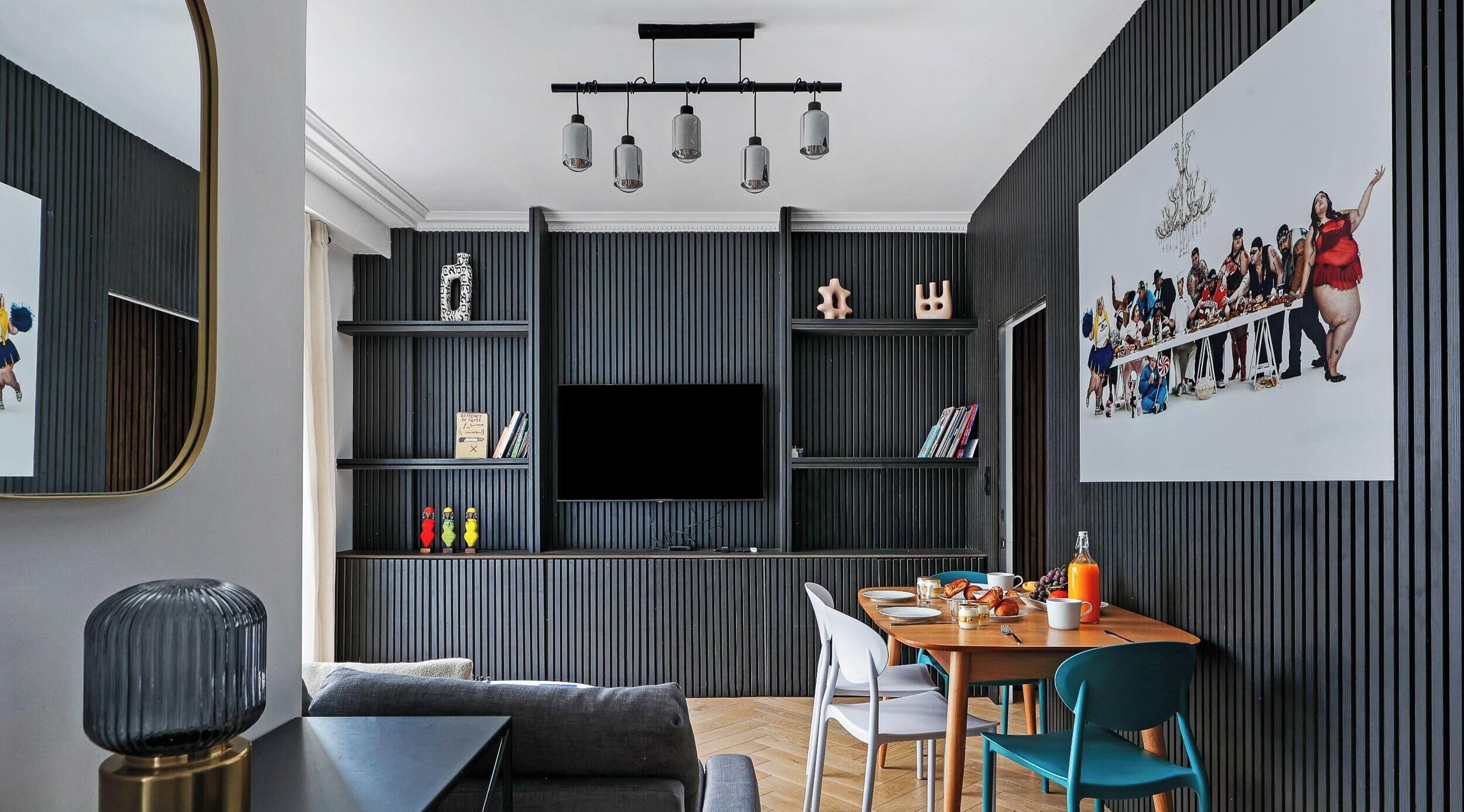 Un salon moderne avec un téléviseur à écran plat, une table à manger avec des chaises et un canapé.