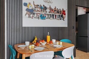 Ein Essbereich mit einem Holztisch, gedeckt für ein Frühstück, einschließlich Teller, Besteck und verschiedenen Speisen.