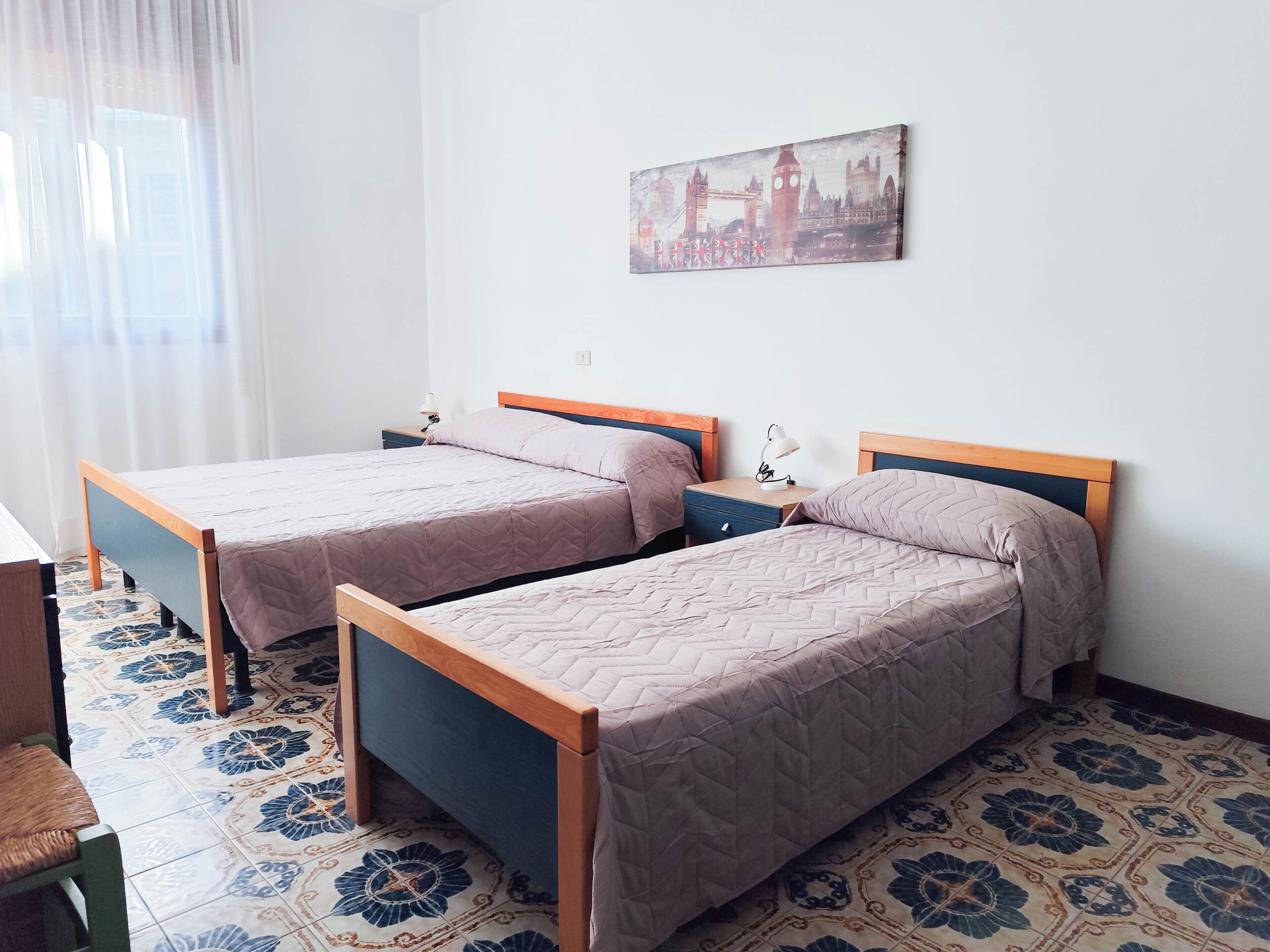 A room with two beds, a desk, and a chair.