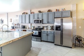 A modern kitchen with grey cabinets, stainless steel appliances, and a marble countertop. - Enjoyable 3-bedroom beach house with AC in Bahía la Choya, Rocky Point (Bahía la Choya)
