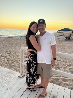 A couple standing on a wooden deck with a beach and ocean in the background. - Enjoyable 3-bedroom beach house with AC in Bahía la Choya, Rocky Point (Bahía la Choya)