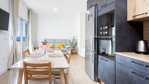 Una cocina moderna con un refrigerador grande, horno y armarios de madera.