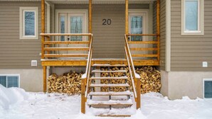 A two-story building with a wooden staircase leading to a balcony. - Hôtel à la maison - Chez Charcole (Saint-Ferréol-les-Neiges)