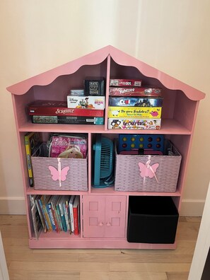 A pink bookshelf with various board games and puzzles. - 3-bedroom Lake house in Port Clinton with AC comfort and game room (Port Clinton)