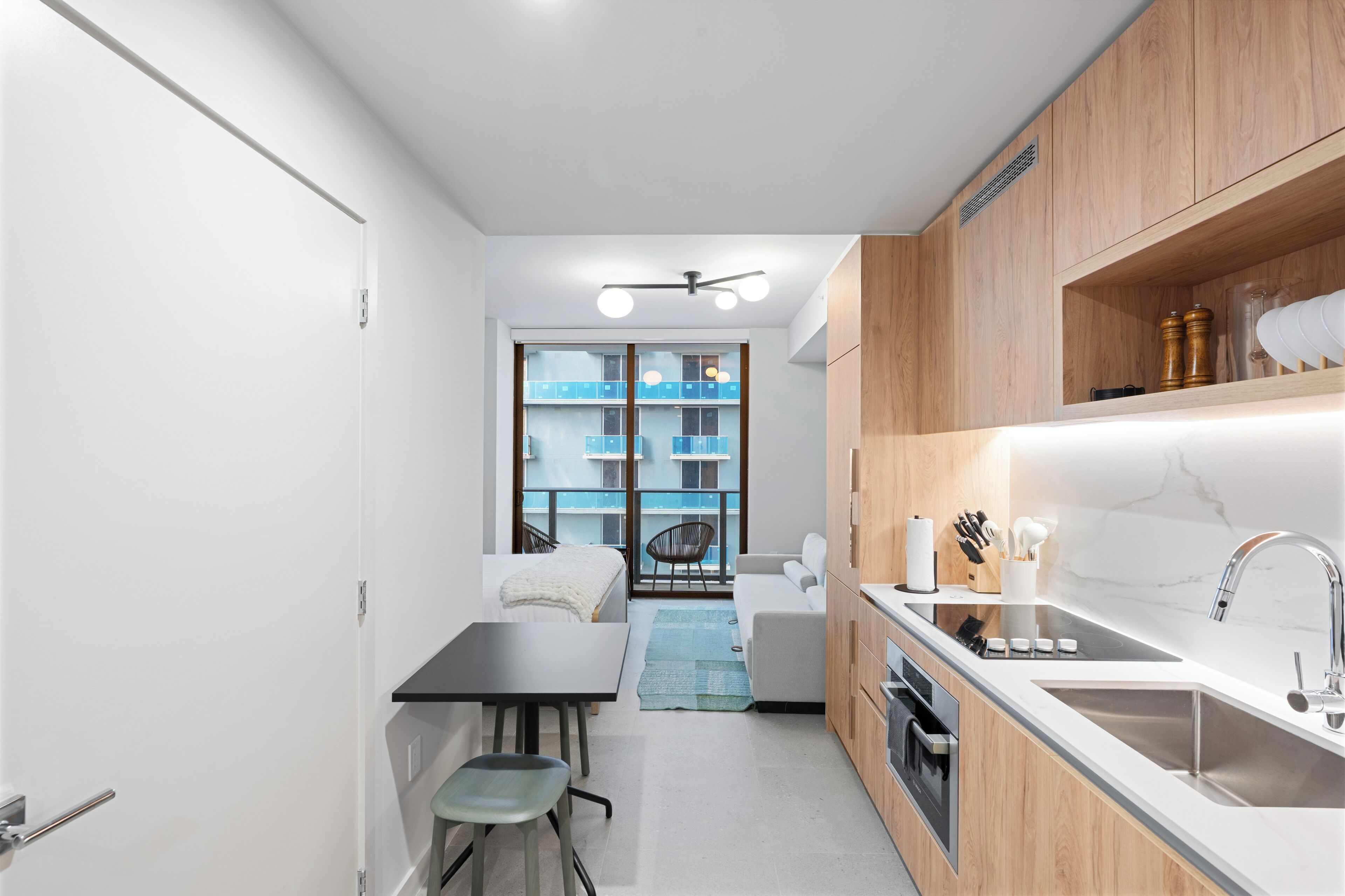 Une cuisine compacte avec un coin repas, une vue sur un balcon et un design moderne.