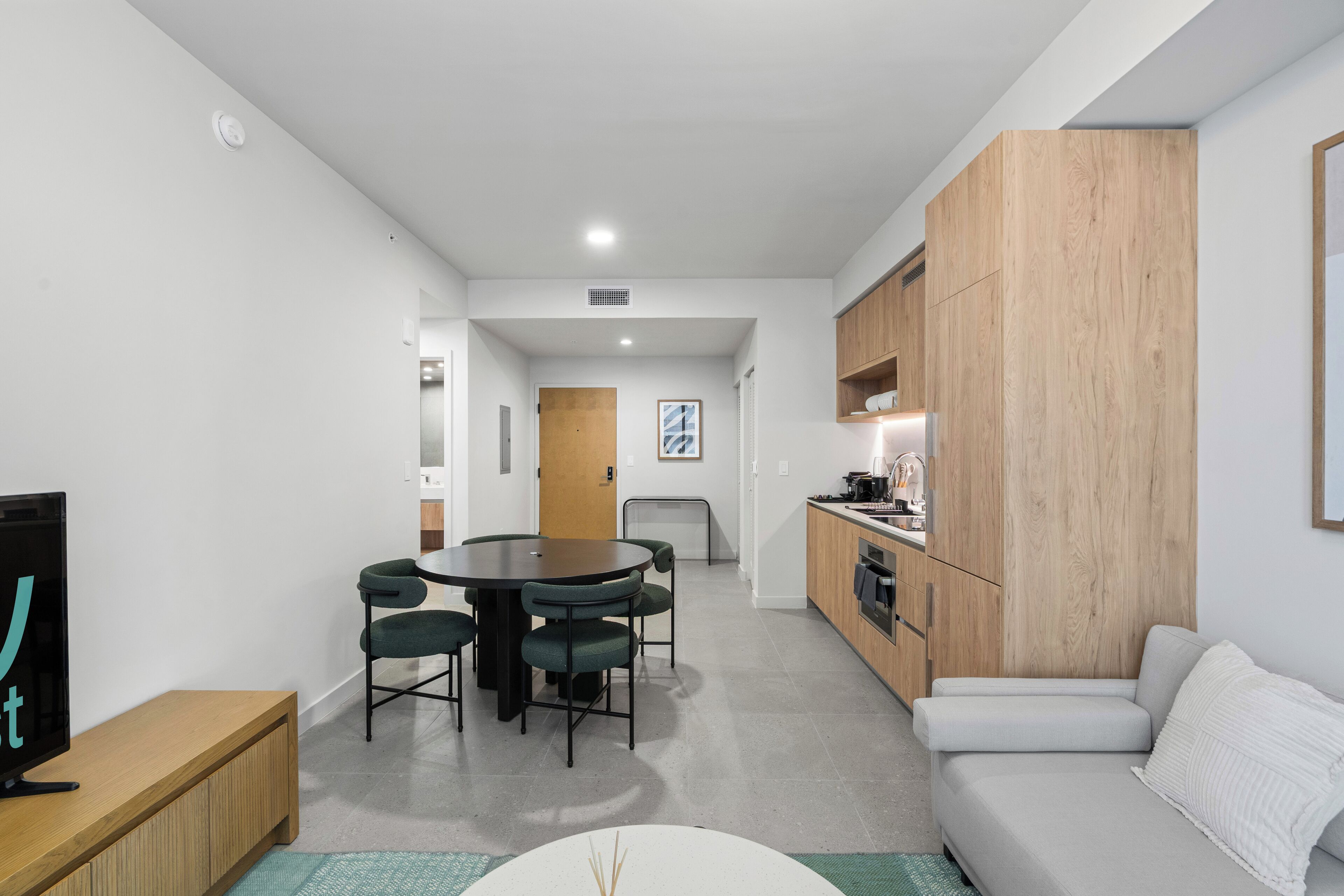 A modern apartment with a dining area, kitchen, and living space.