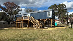 A two-story building with a deck and stairs leading to the entrance. - 3 blocks from boat dock see the festivals and bands from back porc (Homosassa)