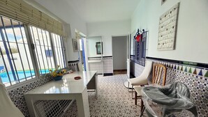 A room with a pool view, a dining area with a table and chairs, and a patterned floor. - The House of Flamenco (Cañada del Rabadán)