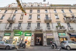 A multi-story building with storefronts including a pharmacy and a restaurant. - Via Piero della Francesca 38 (Milano)