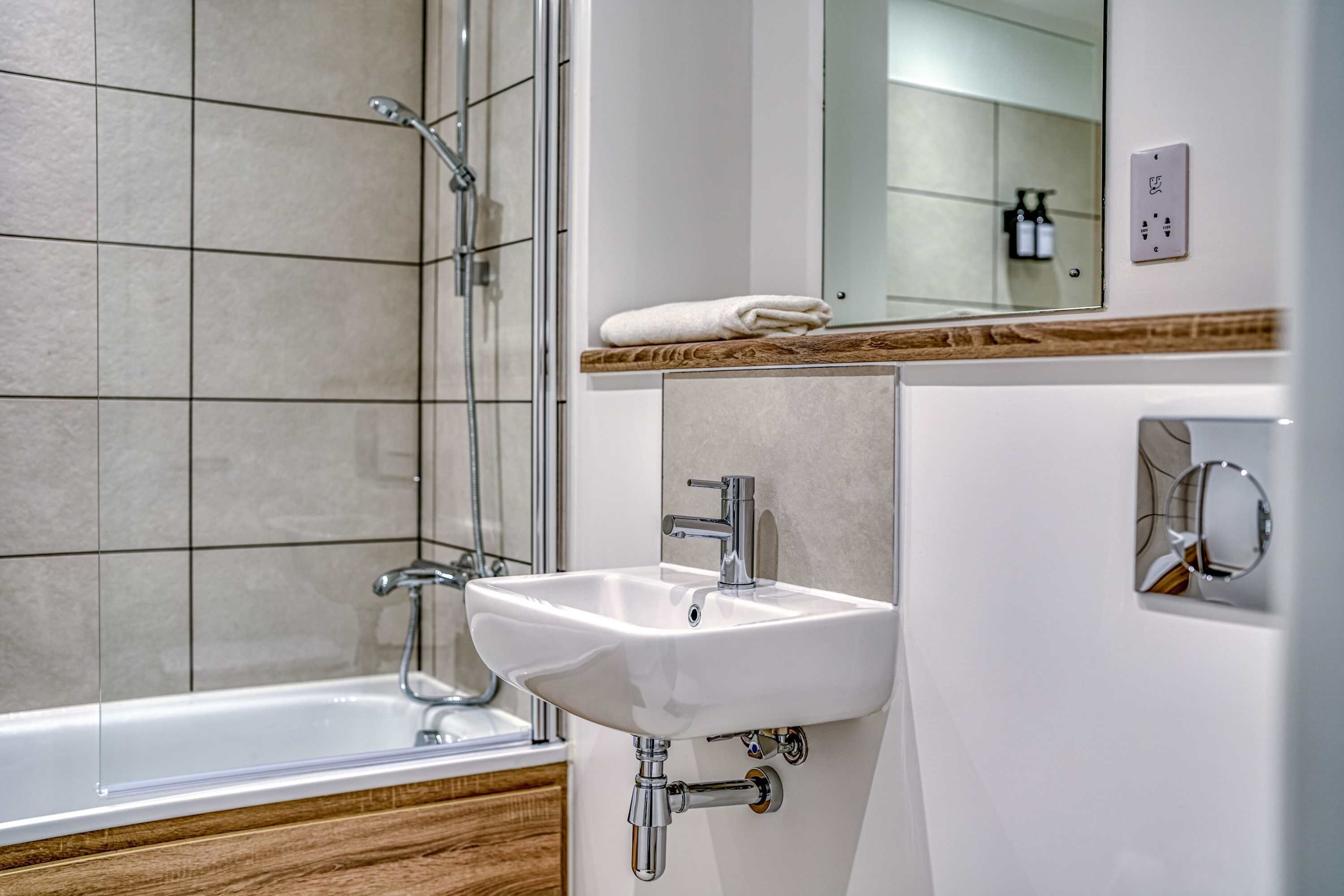 Un bagno con una vasca, un lavandino e uno specchio.