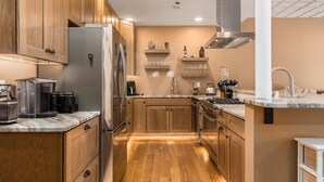 Eine moderne Küche mit Holzausstattung, Edelstahlgeräten und einer Marmarbebene.