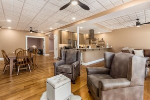 A spacious living area with a dining table, two sofas, and a coffee table. - Timberframe Lodge| Hocking Hills, Luxury, Pond (Rockbridge)