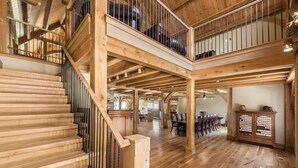 Ein geräumiger Innenraum mit einer Holztreppe, einem Essbereich und einer Küche.