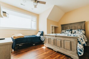 A bedroom with a wooden bed, a desk, and a window. - Hocking Manor | Hocking Hills, 8BR, Indoor Pool (Rockbridge)