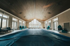 An indoor swimming pool with a wooden ceiling and large windows. - Hocking Manor | Hocking Hills, 8BR, Indoor Pool (Rockbridge)