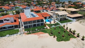 Et resort med flere bygninger, en swimmingpool og et strandområde.