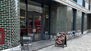 A building with a brick facade, outdoor seating area, and a signboard. - INTERNATIONAL STUDENTS HOUSE VAUXHALL (London)