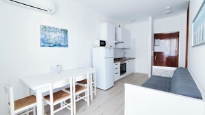 A compact living space with a kitchenette, a dining area, and a seating area. - Comfortable Studio by the sea (Jesolo)