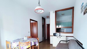 A compact living space with a dining area, kitchenette, and a sofa. - Seaside Apartment With Balcony (Jesolo)