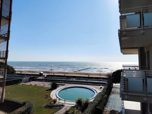 Ein Wohngebäude mit Blick auf Strand und Schwimmbad.