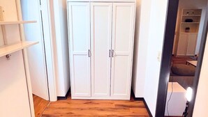 A hallway with wooden flooring, white walls, and a white wardrobe. - House with garden & private parking space in Cologne (Köln)