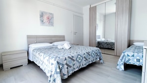 A bedroom with a bed, a nightstand, a wardrobe, and a mirror. - Spacious Flat With Balcony by the sea (Jesolo)
