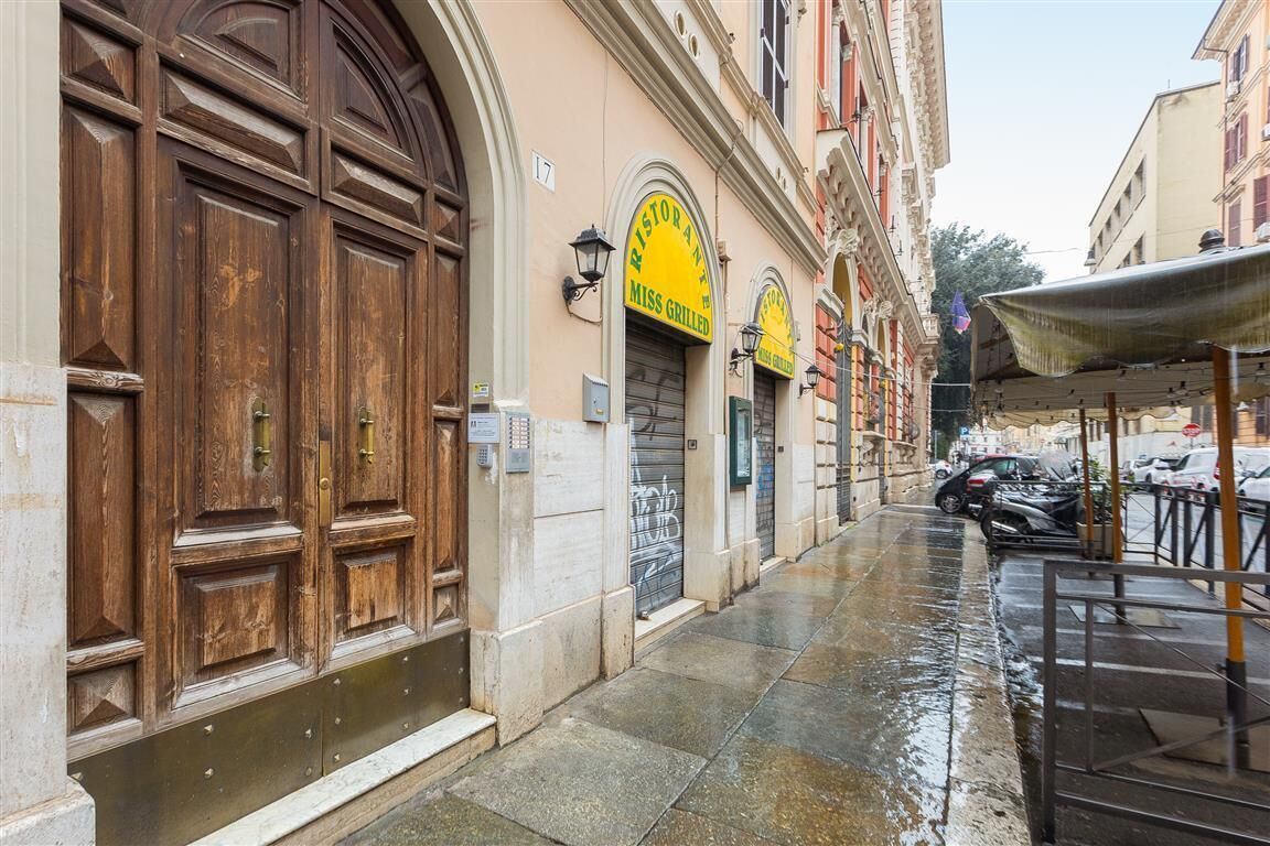 A narrow street with a restaurant named 'Miss Grilled' and a wooden door on the left.